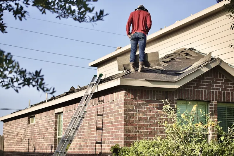 Professional roofer working on a residential roof in Spotswood Manor